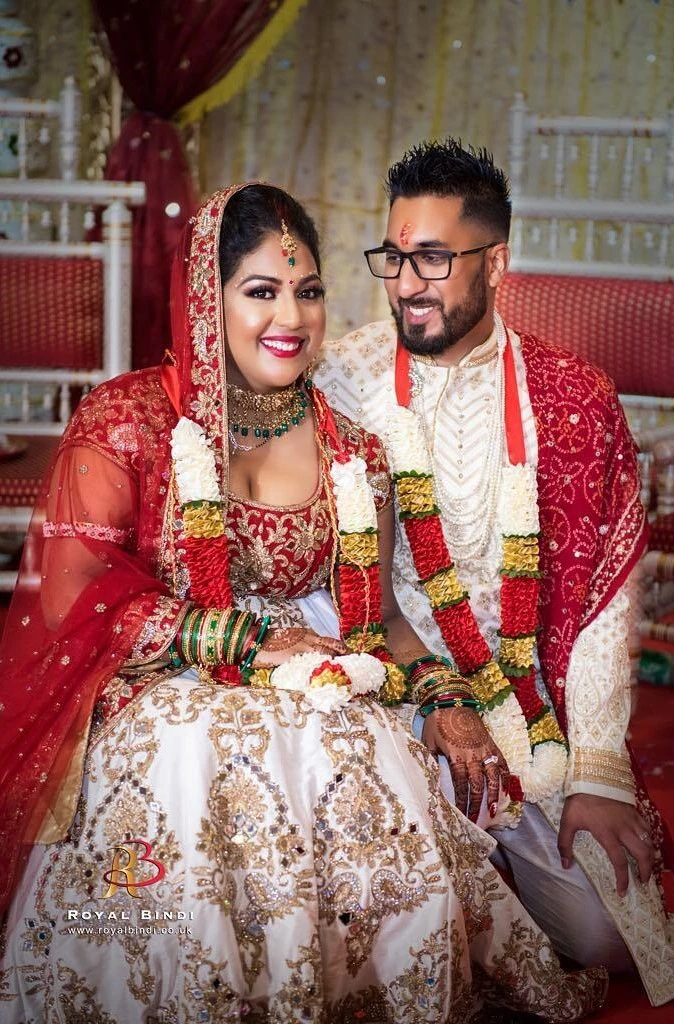 Smiling Gujarati couple in traditional attire, captured in a vibrant and joyous wedding photoshoot.